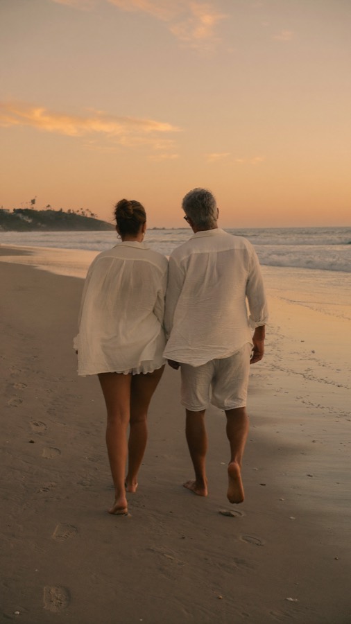 Couple walking on the beach at sunset
