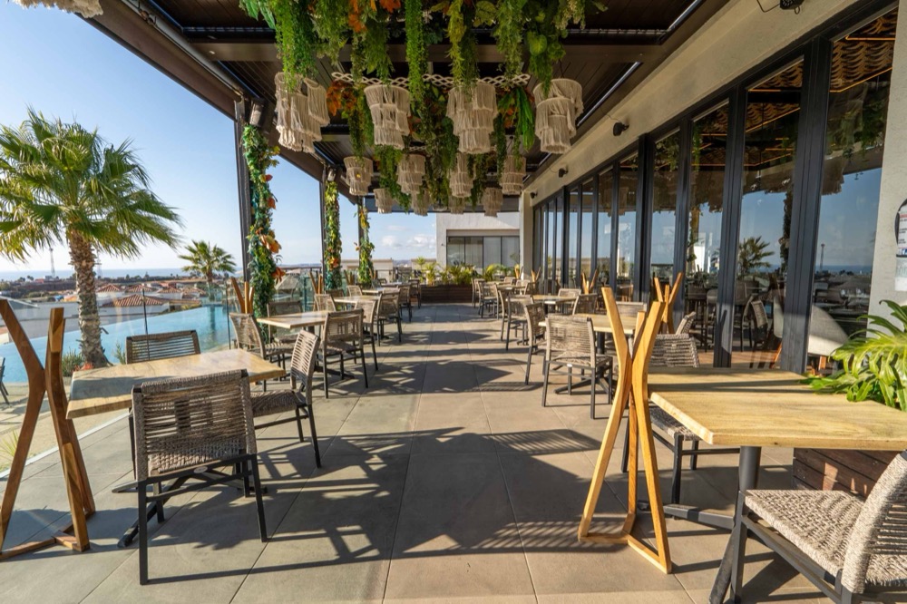 Sunlit dining terrace with ocean view at the residents' club